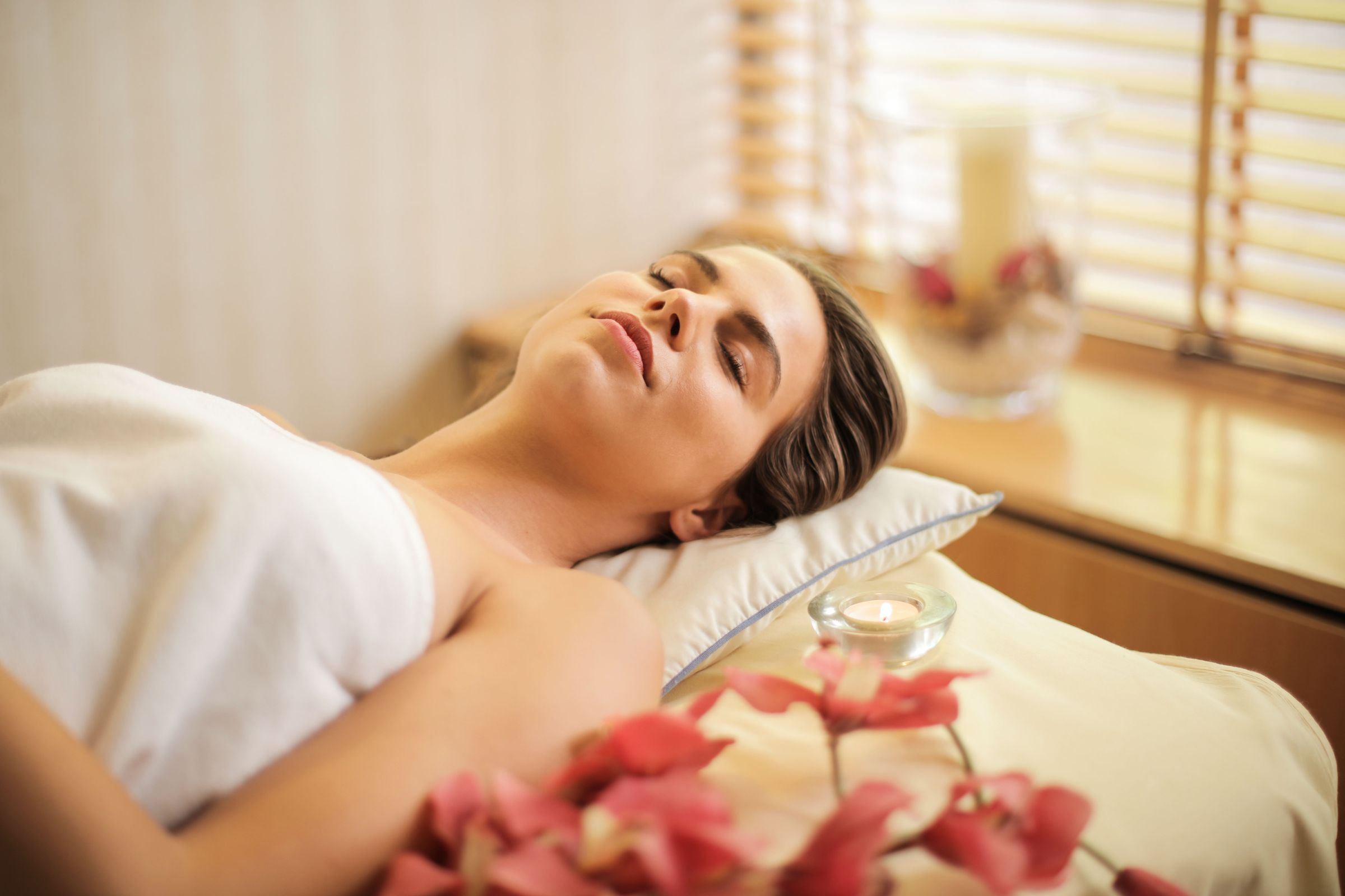 A person resting calmly with eyes closed during a relaxation treatment